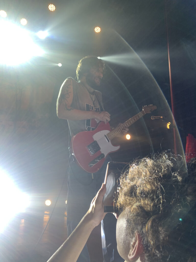 Na imagem o guitarrista do Grilo aparece ao centro tocando em um show