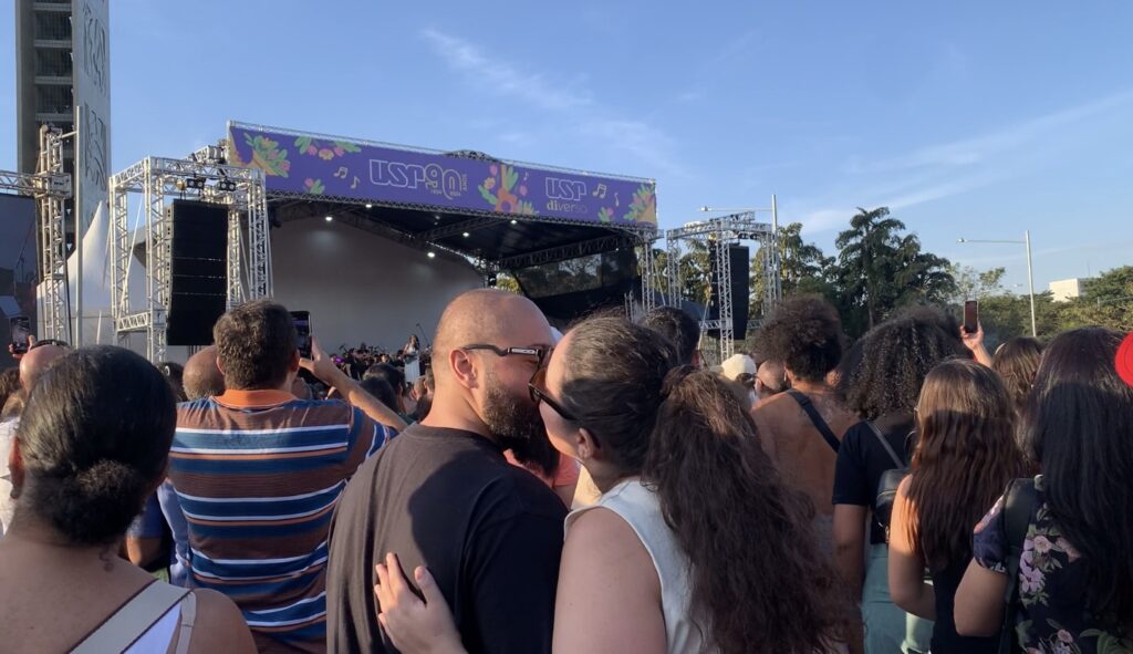 Na imagem um casal se beija em meio a multidão do show de Marisa Monte