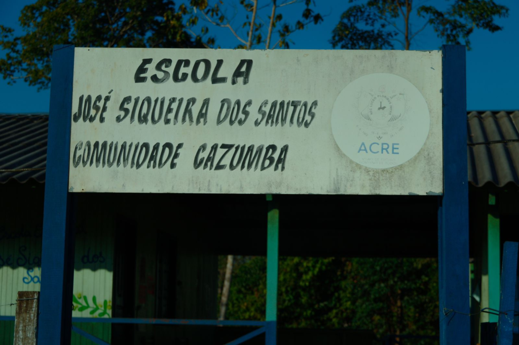 Placa da fachada de uma escola, com as inscrições "Escola José Siqueira dos Santos Comunidade Cazumba"