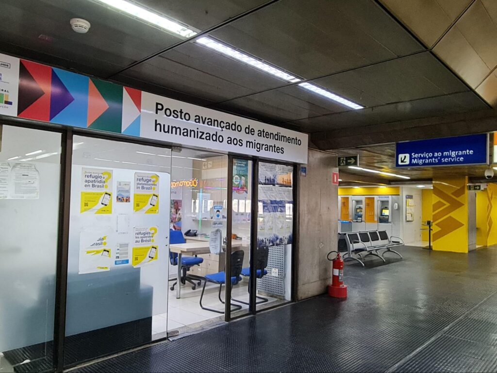 Sala com placa escrito "posto avançado de atendimento humanizado aos migrantes"