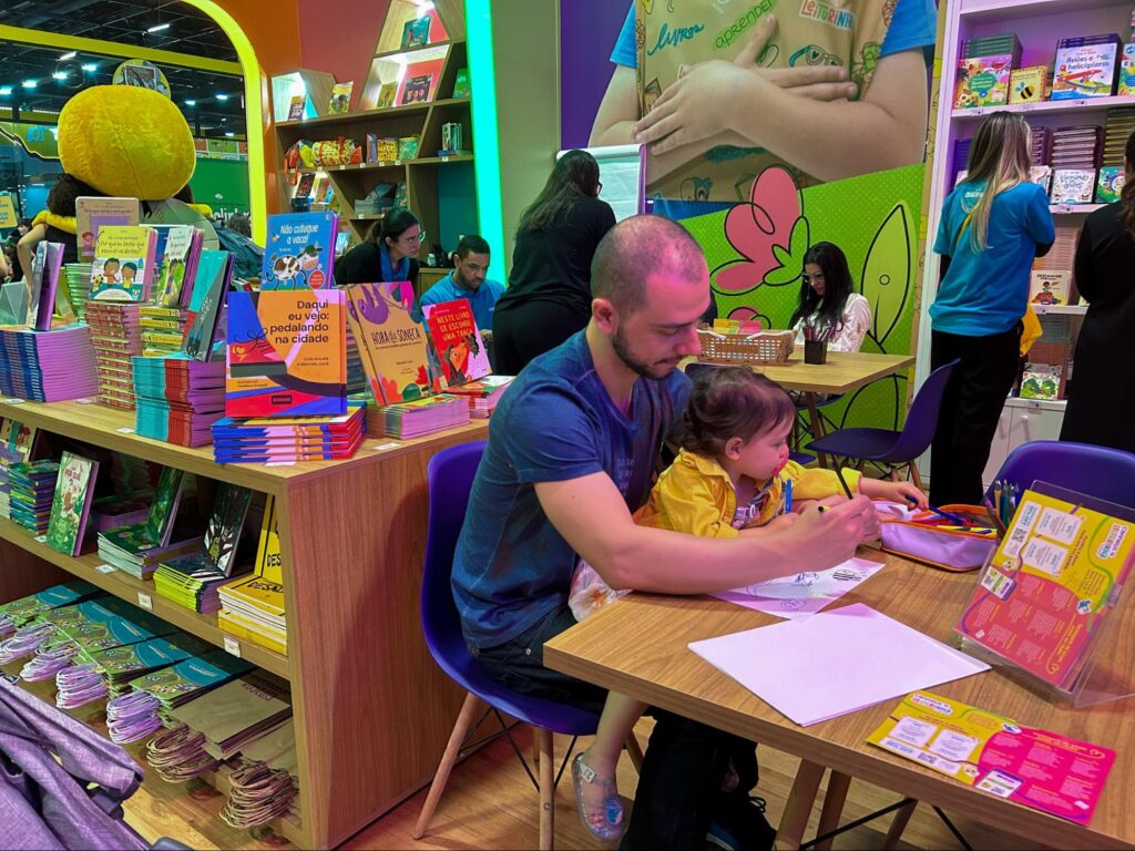 Em um dos estandes da Bienal do Livro, um pai desenha junto com seu filho