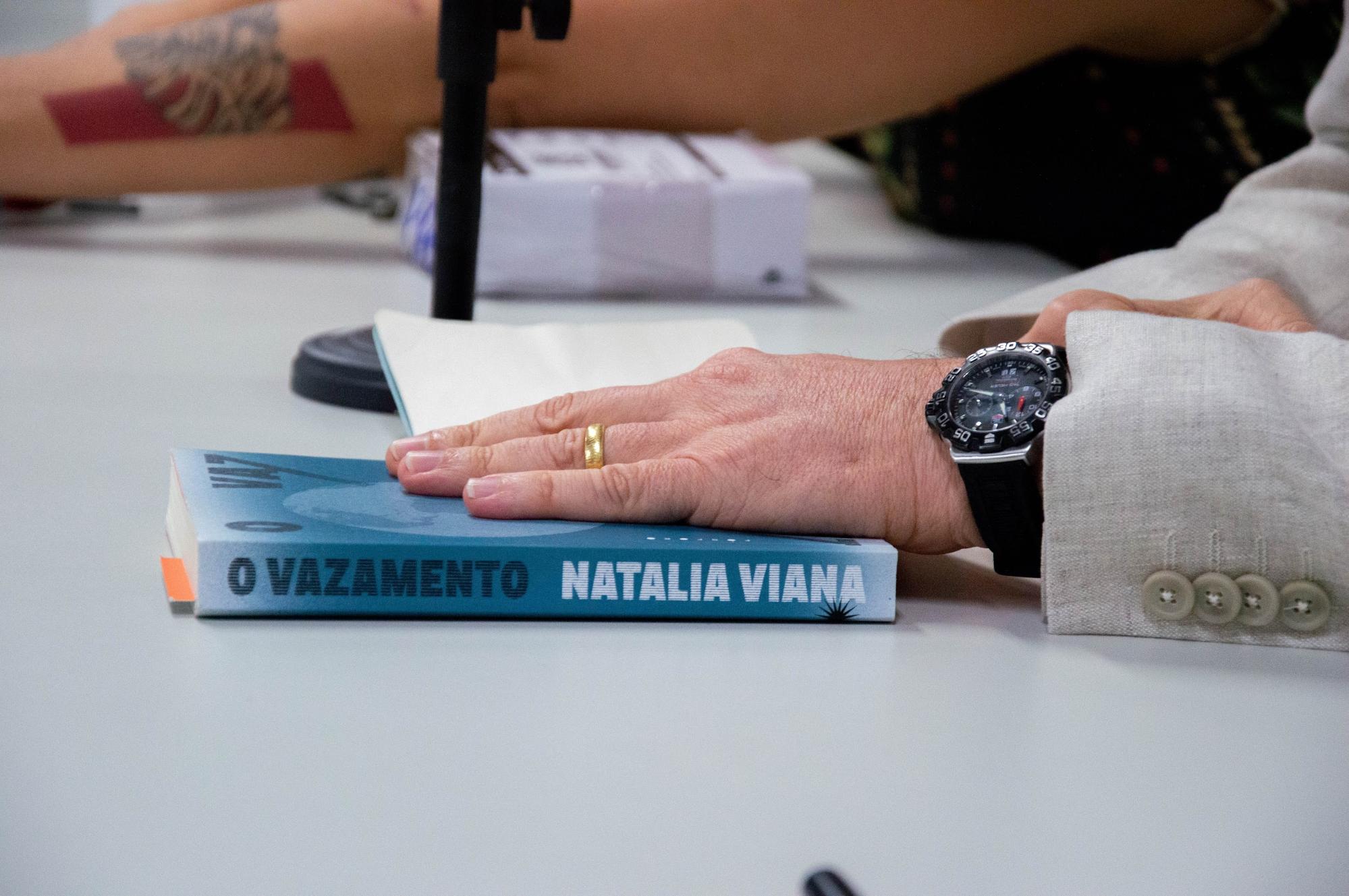 Pessoa com livro sobre a mesa branca