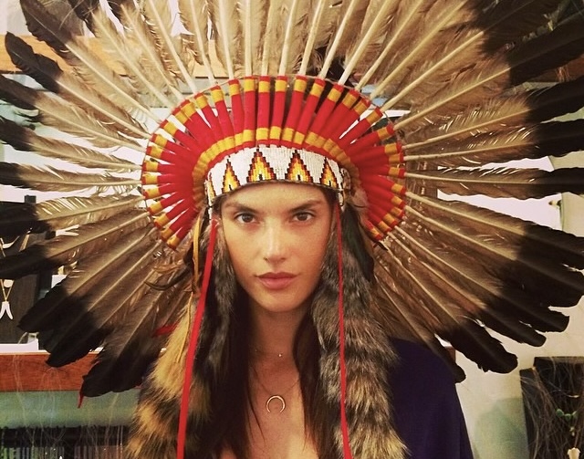 Modelo Alessandra Ambrósio usando um cocar grande.