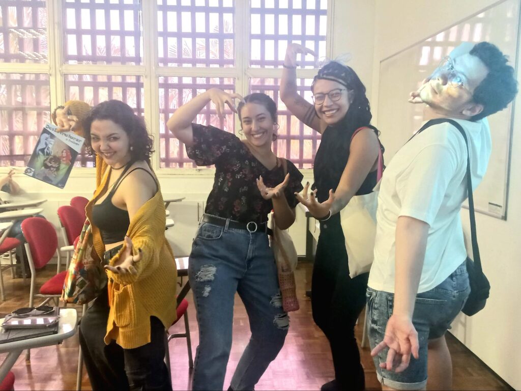 A imagem de capa da matéria tem quatro estudantes em uma sala de aula fazendo poses com os braços para a câmera