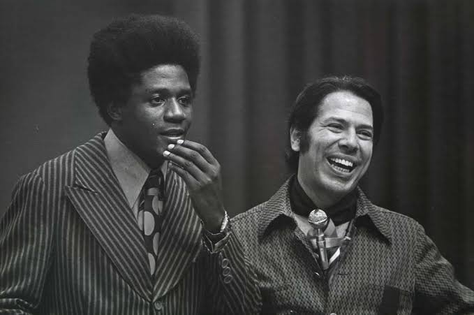 Silvio Santos e o cantor Tony Tornado, ambos jovens. A foto está em preto e branco. 