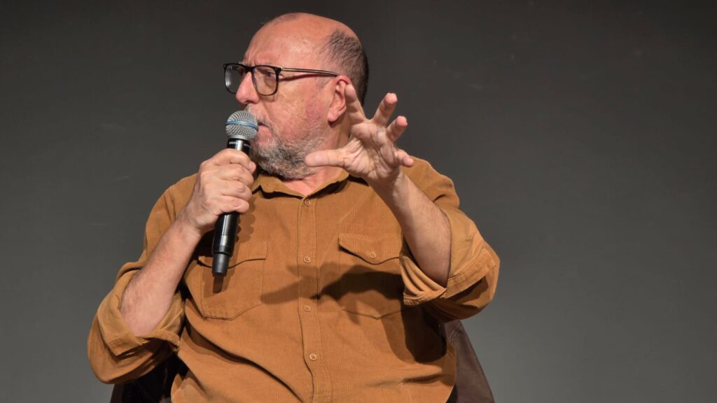 Xico Sá sentado e olhando para a esquerda