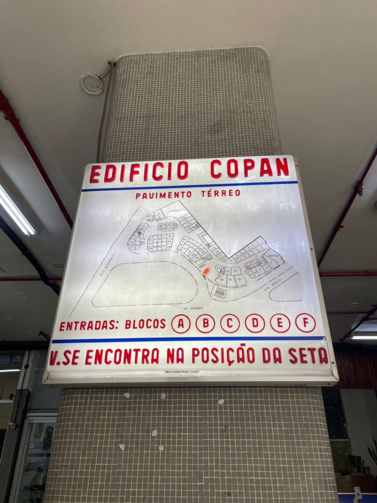 Placa luminosa antiga do Edifício Copna, com seu mapa desenhado e as entradas dos blocos marcadas em vermelho.