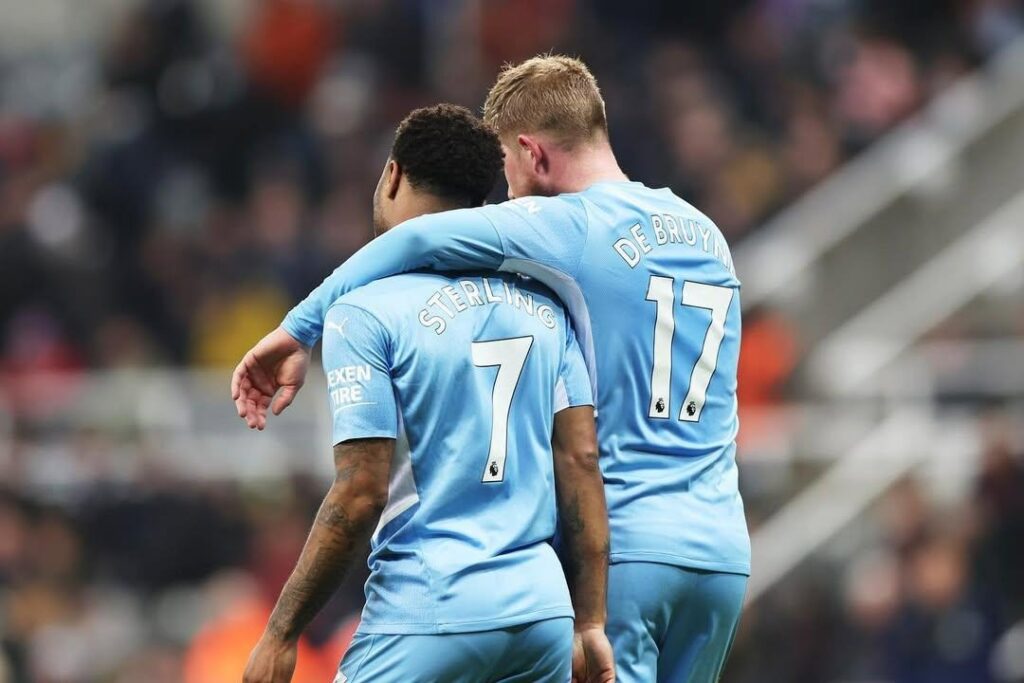 Jogadores Sterling e de Bruyne se abraçam em campo