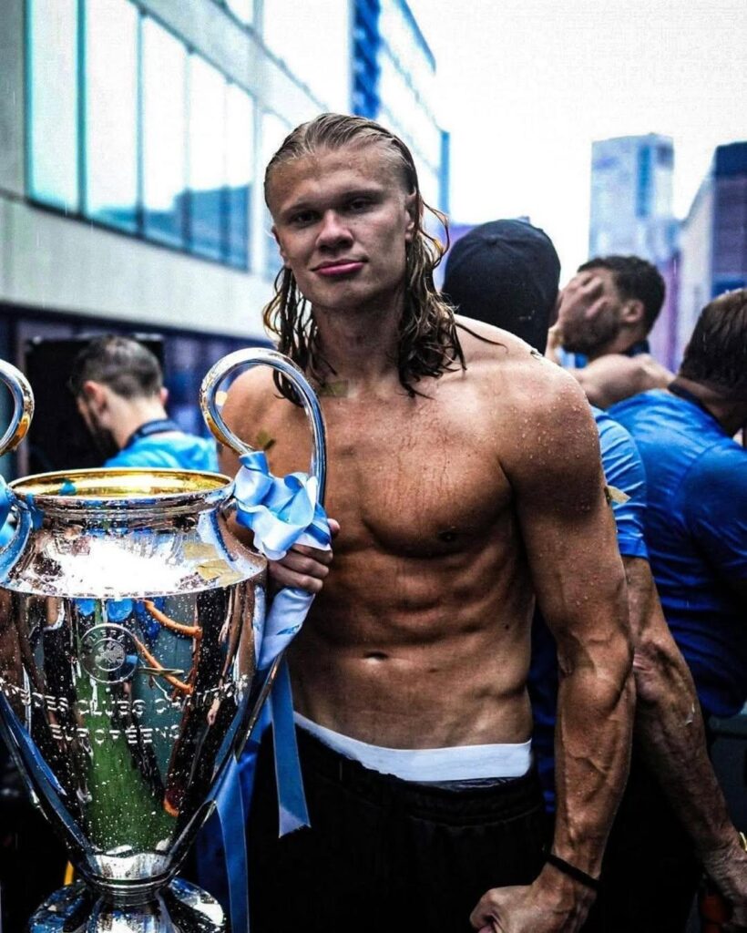 erling haaland com o troféu de campeão do manchester city