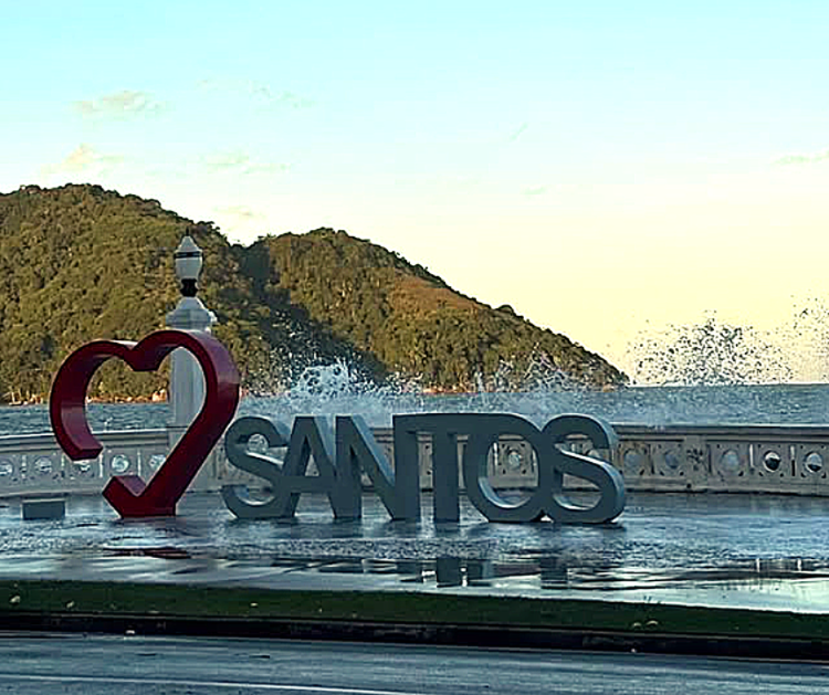 Área próxima ao mar com letreiro de Santos