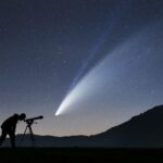 Silhueta de homem observando céu estrelado com um telescópio