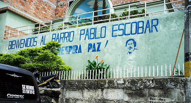 Parede pintada com palavras em espanhol e o desenho de Pablo Escobar