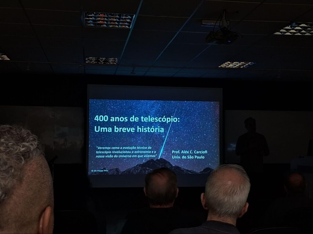 Foto de uma palestra que fala sobre a história do telescópio.