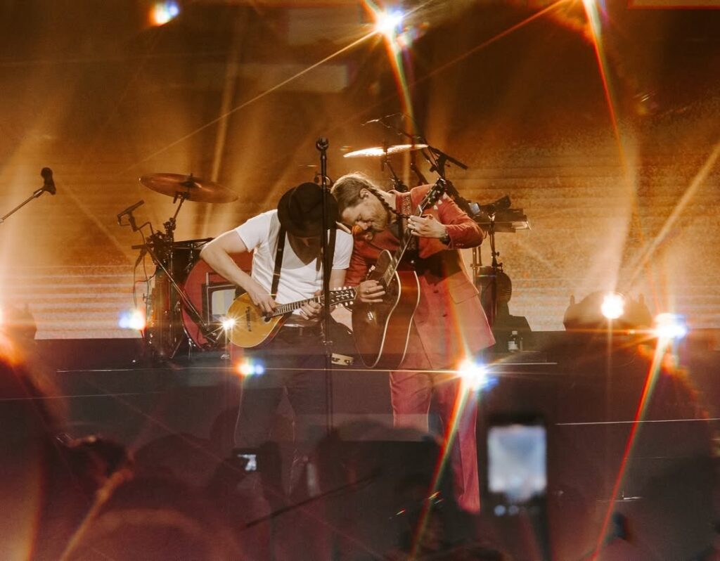 membros da bandatocam instrumentos de corda sob uma luz indireta e quente