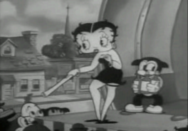 Betty Boop, uma personagem de cabelos curtos e encaracolados, longas pernas e corpo curvilíneo é apresentada em movimento em cima de um palco com um artefato não identificado em suas mãos. Possui maquiagem forte e roupas curtas.