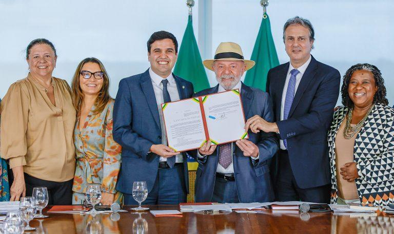 Presidente Lula de chapéu segurando o projeto de lei ao lado de políticos
