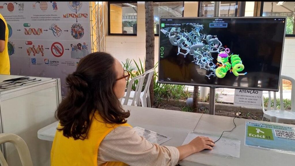 Mulher observa estrutura celular em tela.