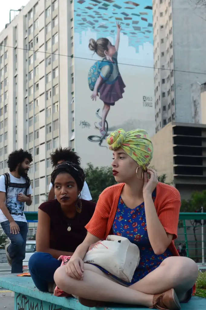 Duas mulheres negras sentadas em um banco