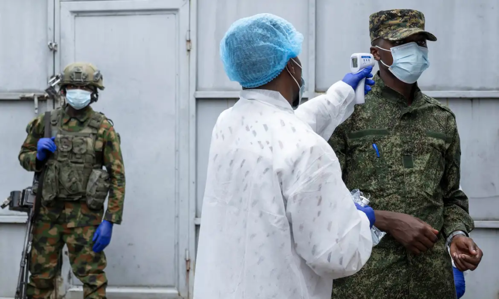 Pessoa vacinando militar contra o ebola