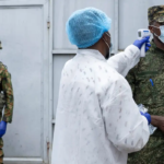 Pessoa vacinando militar contra o ebola
