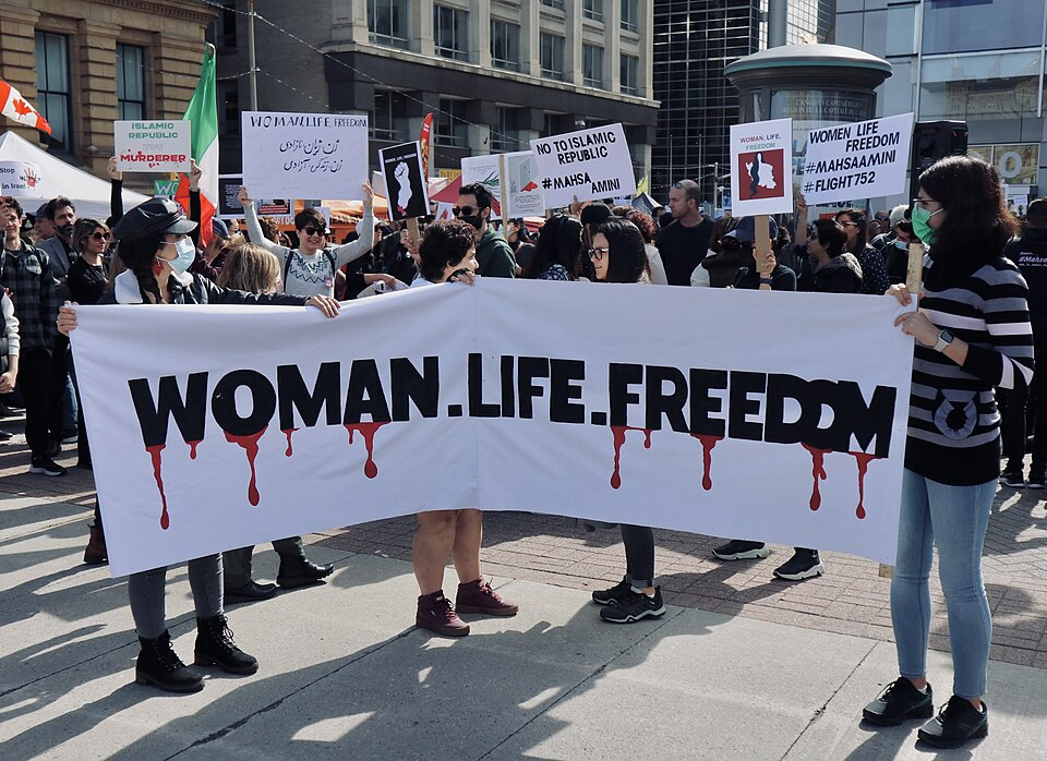 Foto de uma faixa com o lema "Mulher. Vida. Liberdade.", que nomeia o movimento feminista no Irã.