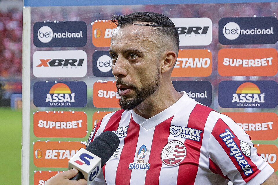 Na imagem, um jogador de futebol em entrevista a jornalistas