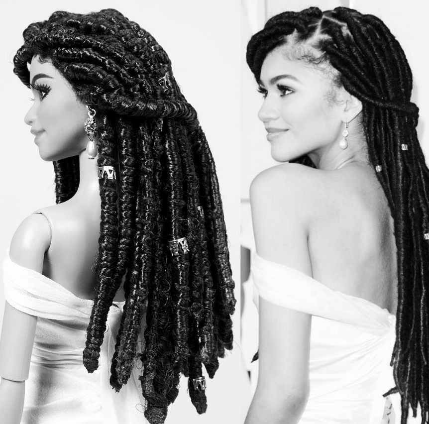 Fotografia em preto e branco com enquadramento duplo na vertical, apresentando uma comparação em plano médio entre uma boneca de brinquedo (à esquerda) e a atriz Zendaya (à direita). À esquerda, a boneca é vista de perfil esquerdo, usando um vestido branco ombro a ombro e brincos de gota com pérola. Seu cabelo escuro está estilizado em longos dreadlocks decorados com anéis metálicos prateados espalhados ao longo dos fios. À direita, Zendaya é fotografada em uma pose quase idêntica de perfil, olhando suavemente para a esquerda com um meio sorriso. Ela veste o mesmo modelo de vestido branco ombro a ombro e brinco de pérola pendente, exibindo longos dreadlocks escuros ornamentados com pequenos anéis metálicos prateados. O fundo de ambos os lados é claro e neutro.