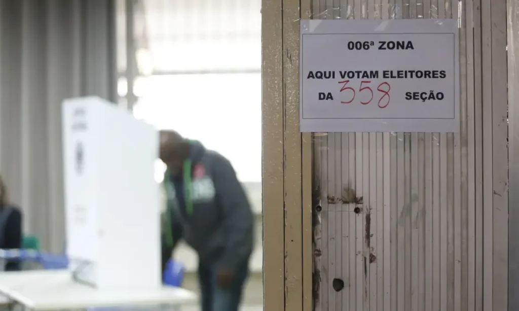 Na imagem, uma pessoa realizando uma votação