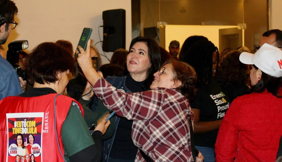Na imagem, a candidata Simone Tebet tirando foto com uma admiradora durante o Direitos Já!
