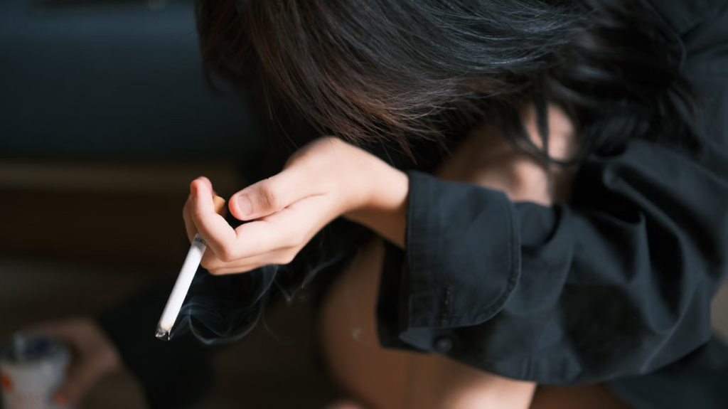Jovem segurando cigarro