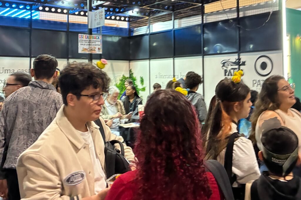 Visitantes e leitores circulando entre os estandes de editoras na Bienal Internacional do Livro.