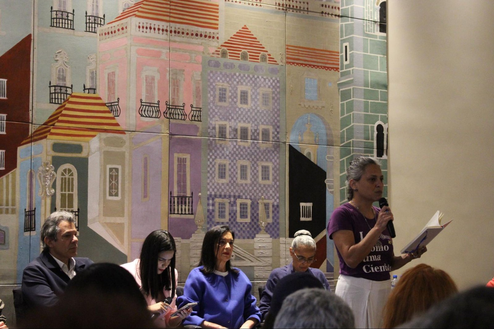 Na imagem, uma mulher discursando no evento do Direitos Já
