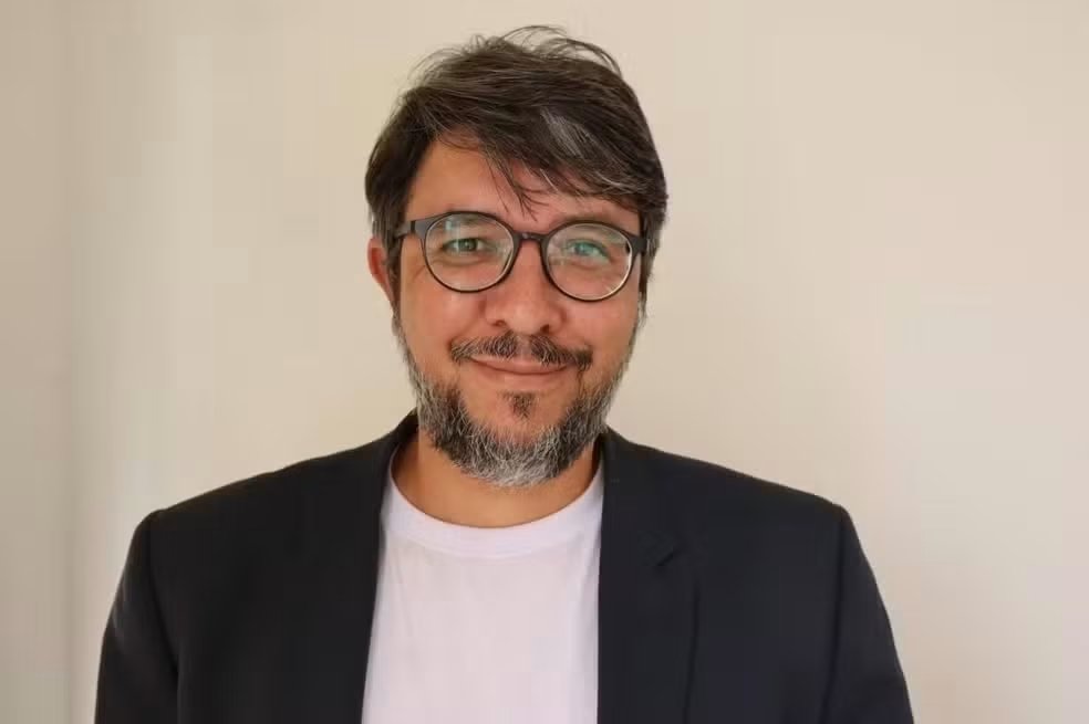 Homem branco de óculos sorrindo