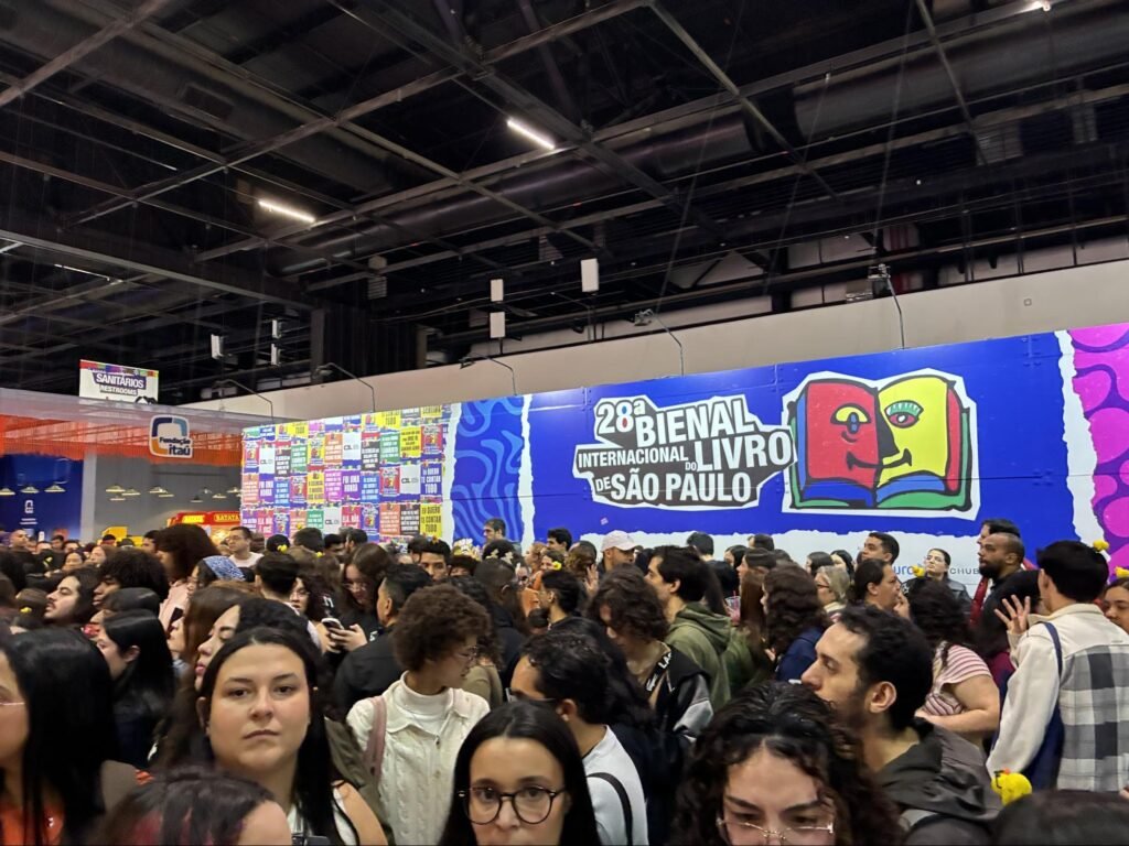 Visitantes e leitores circulando entre os estandes de editoras na Bienal Internacional do Livro.