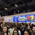 Visitantes e leitores circulando entre os estandes de editoras na Bienal Internacional do Livro.
