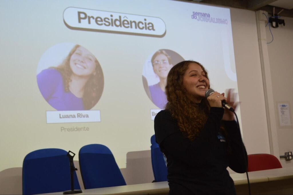 Foto em que Luana Riva, presidente da Jornalismo Jr., realiza um discurso