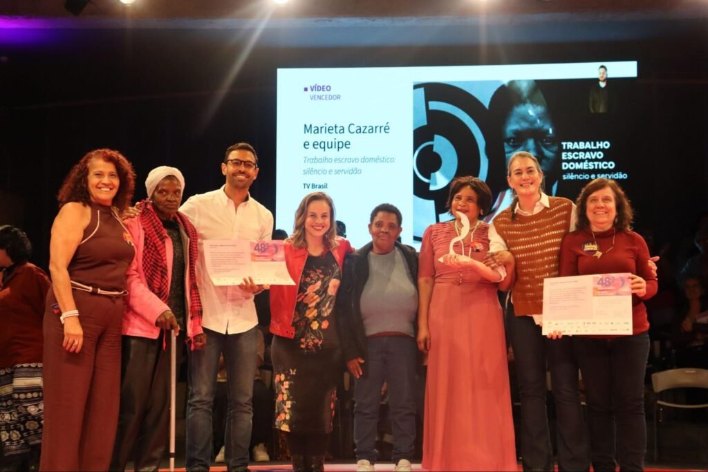 Homens e mulheres abraçados em um palco