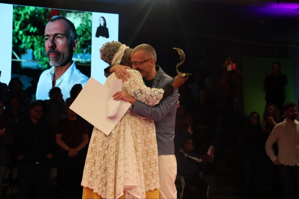 Homem e mulher se abraçando no palco