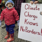 Imagem de um cartaz de protesto sobre as mudanças climáticas junto com uma criança