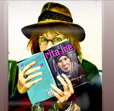 Rita Lee com sua auto-biografia em mãos