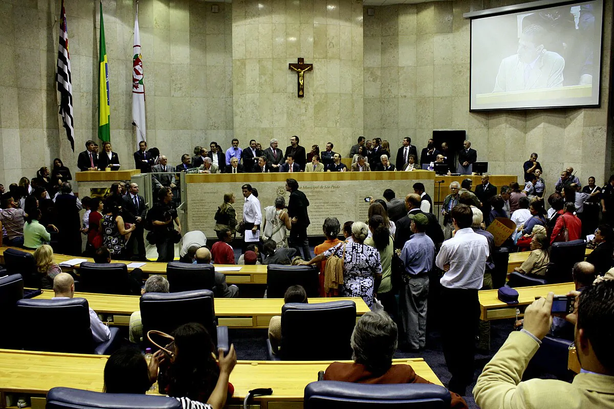 Câmara Municipal de São Paulo em audiência pública. Imagem conta com vários vereadores , em pé, em uma discussão.