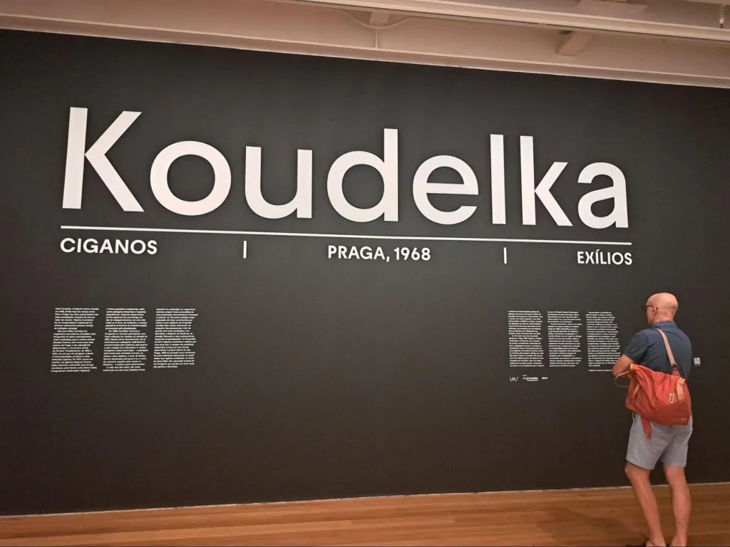 Um visitante lê as informações em parede da exposição sobre Koudelka