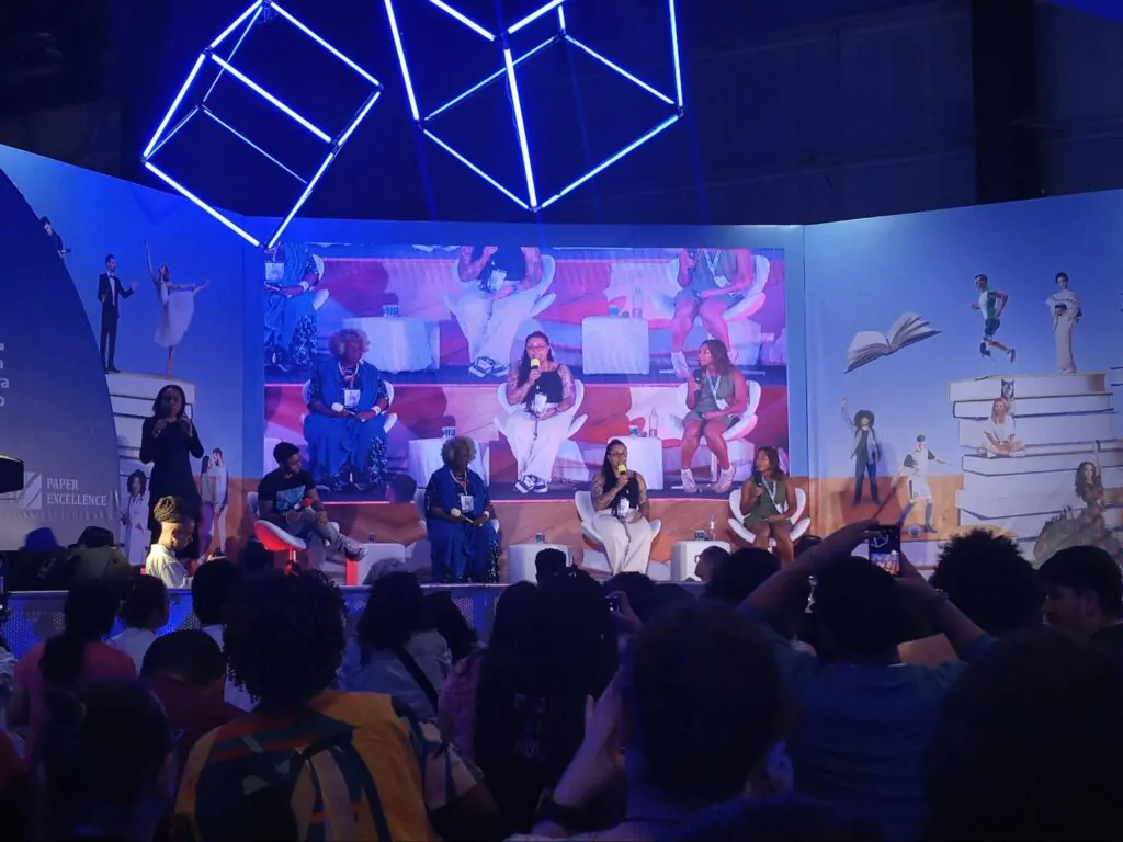 No palco da Arena Cultural, Conceição Evaristo aparece ao lado de influenciadoras digitais e intérprete de libras