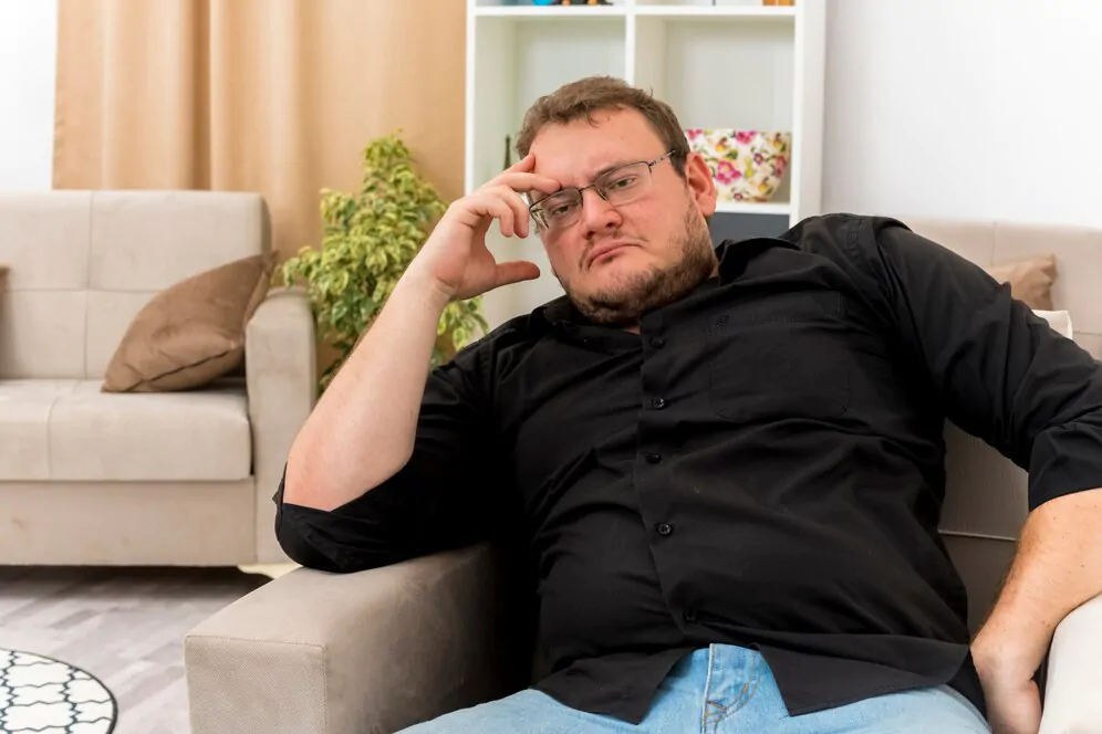 Homem com expressão de insatisfeito e cansado, demonstrando as consequências das alterações no metabolismo de hormônios para a vida adulta