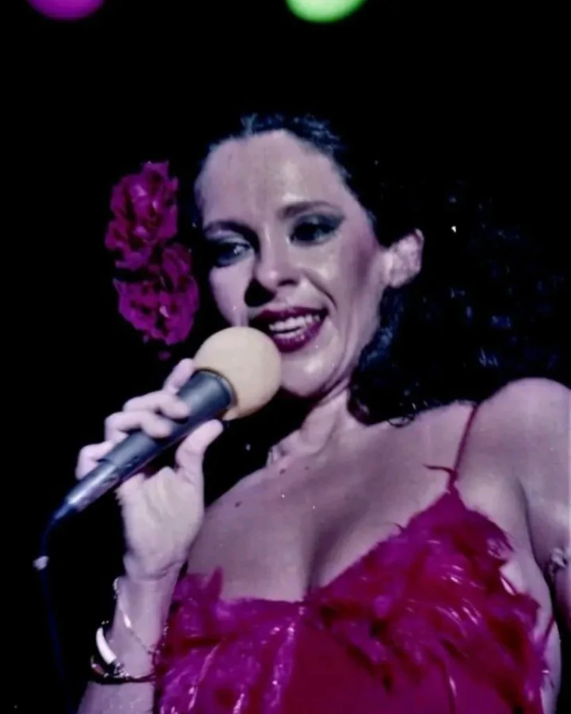 Gal Costa em "Gal Tropial". A cantora usa um vestido e uma flor rosa-choque.