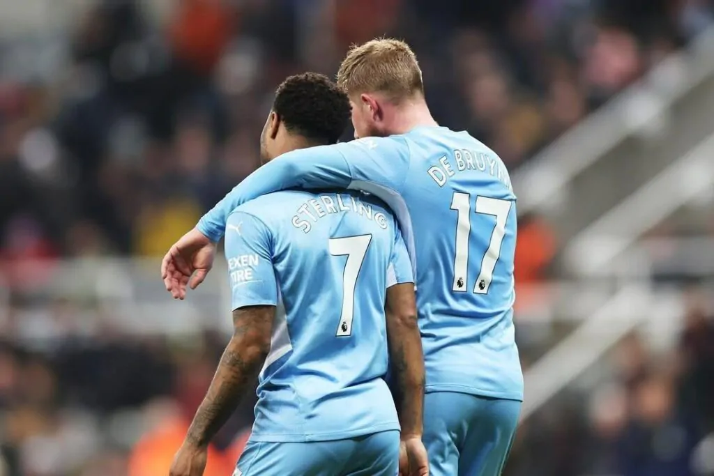 Jogadores Sterling e de Bruyne se abraçam em campo