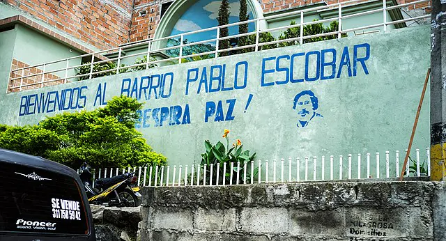 Parede pintada com palavras em espanhol e o desenho de Pablo Escobar