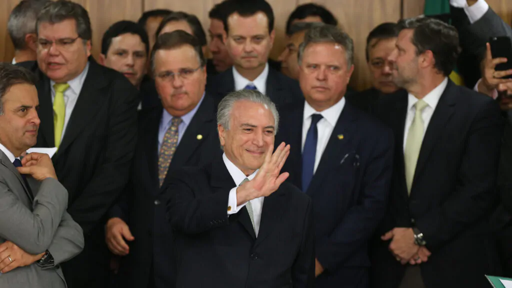 Michel Temer, com seus ministro atrás, acenando para platéia