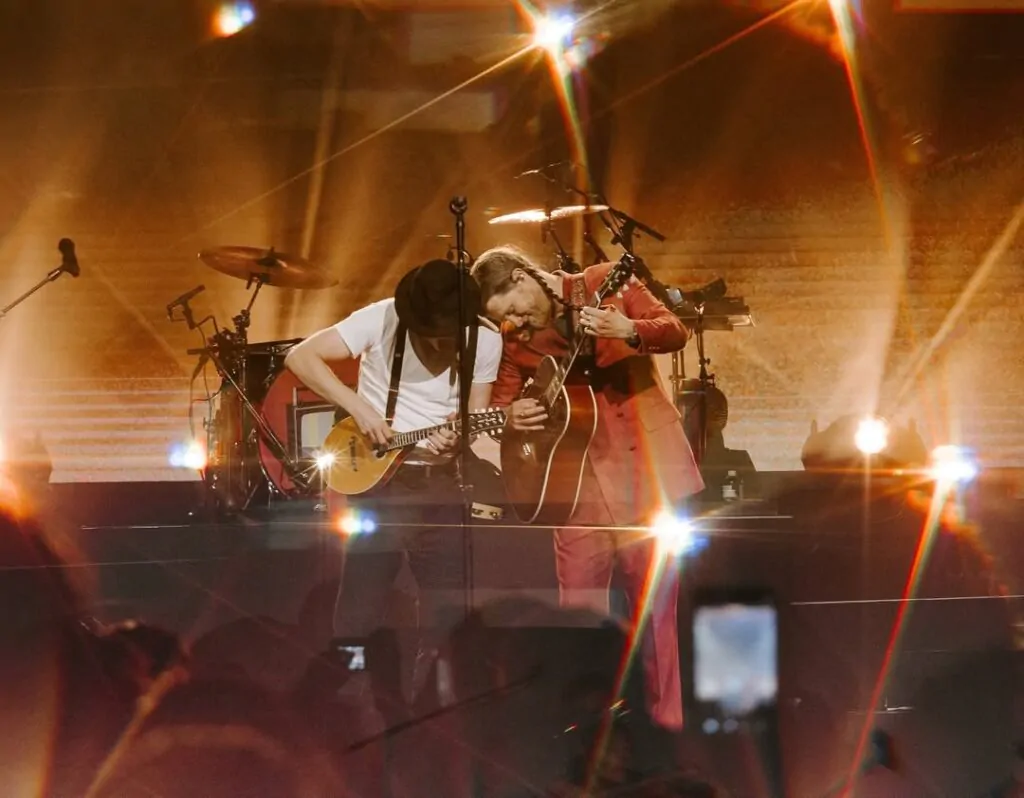 membros da bandatocam instrumentos de corda sob uma luz indireta e quente