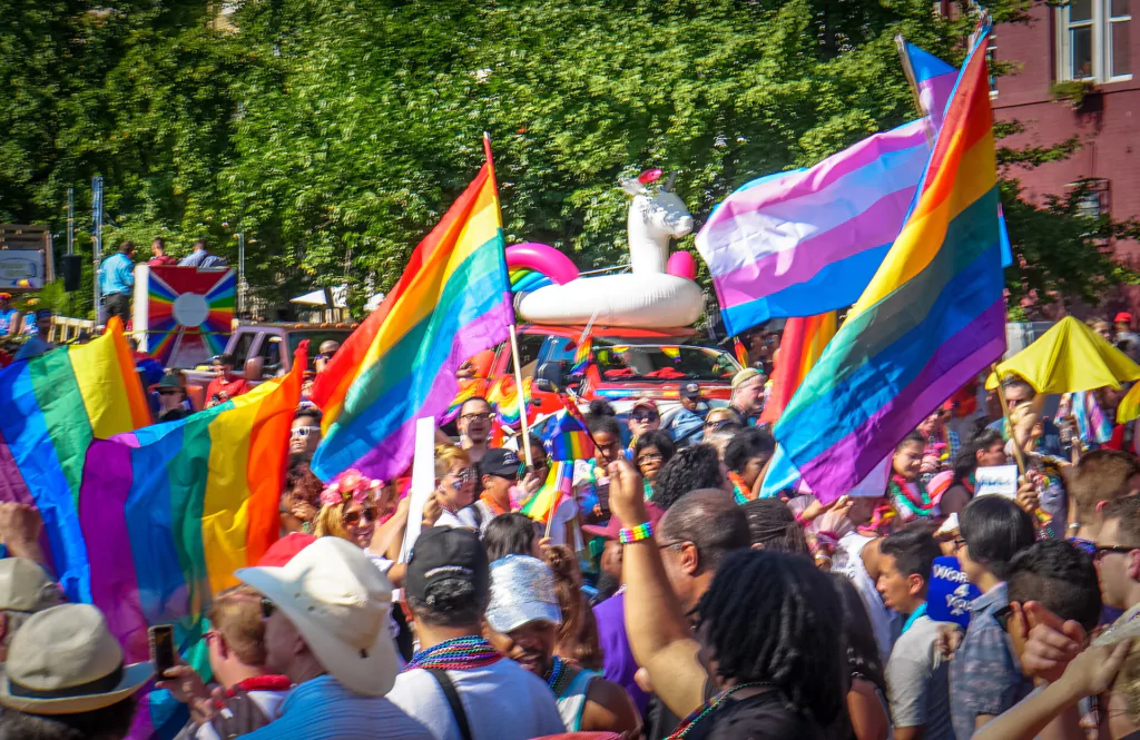 Pessoas balançando bandeiras LGBT na Parada do Orgulho